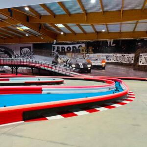 piste de course en salle avec photo historique du Mans de 1966 sur le mur